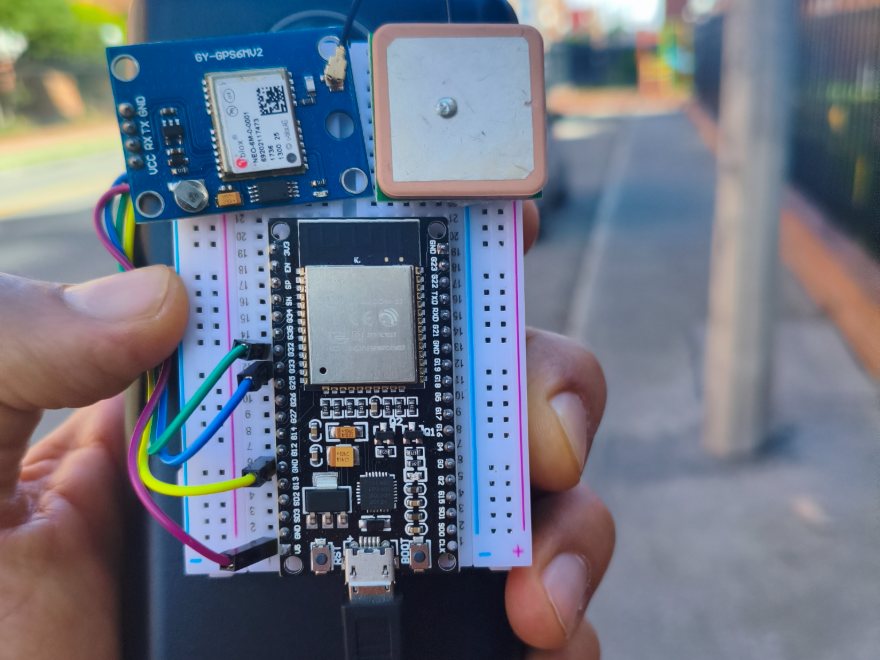 Rastreador GPS con ESP32 y módulo NEO-6M sobre protoboard, sostenido en la calle